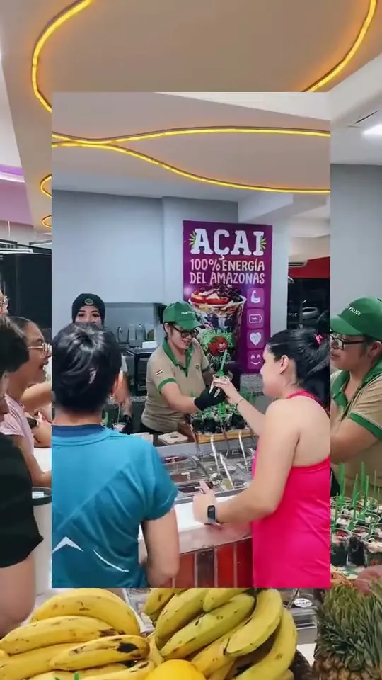 El equipo de Quiero Fruta, de uniforme verde, prepara bandejas de camadinhas en el local del Club Fitness